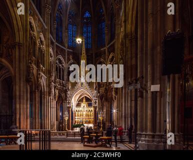 Vista notturna interna con altare maggiore, coro, della Chiesa votiva neo-gotica (Votivkirche), Vienna, Austria. Foto Stock