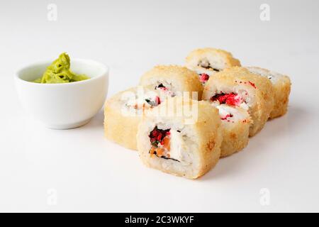 Involtini di riso giapponesi con semi di salmone e wasabi su sfondo bianco. Primo piano Foto Stock