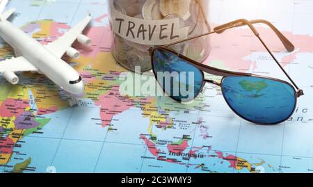 pianificare di viaggiare con gli occhiali da sole sulla mappa del mondo in concetto di viaggio Foto Stock