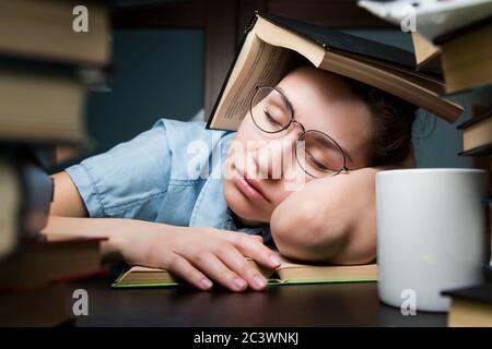 studentessa che si è addormentata mentre studiava a casa la sera Foto Stock