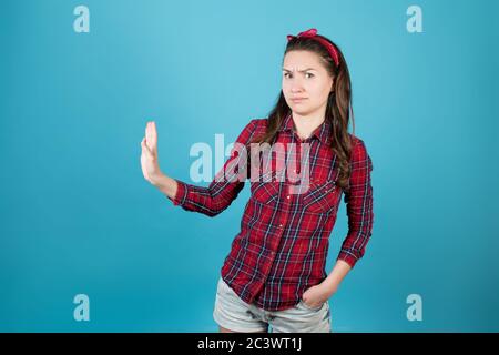 Una ragazza di campagna in una camicia rossa di plaid è insoddisfatta con qualcosa Foto Stock