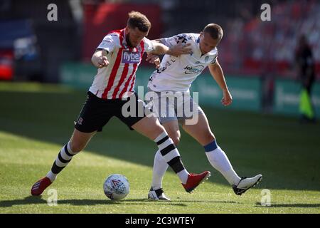 Pierce Sweeney (a sinistra) di Exeter City e Luke Norris di Colchester United combattono per la palla durante la partita Play Off di Sky Bet League Two al St James Park di Exeter. Foto Stock