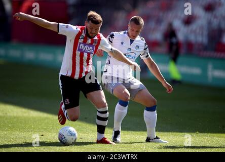 Pierce Sweeney (a sinistra) di Exeter City e Luke Norris di Colchester United combattono per la palla durante la partita Play Off di Sky Bet League Two al St James Park di Exeter. Foto Stock