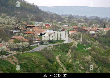 Strada che passa attraverso il villaggio di Valea Sarii, Vrancea County, Romania. Paesaggio primaverile. Foto Stock