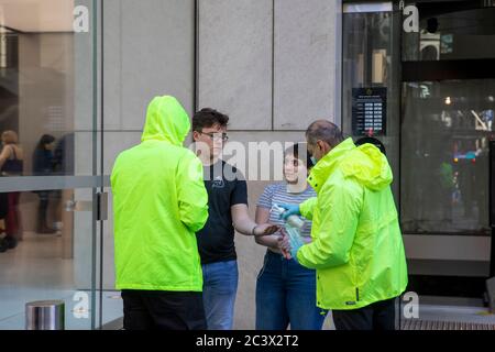 Covid 19 e il negozio di punta Apple a Sydney, il personale addetto alla sicurezza controlla la temperatura e la salute dei clienti che consegnano le maschere per entrare nel negozio Foto Stock