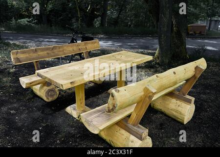 Nuove panchine e un nuovo tavolo fatto di enormi tronchi di alberi in un'area di riposo per escursionisti e ciclisti vicino a Gifhorn, Germania Foto Stock