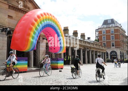 L'arcobaleno gonfiabile installato a Covent Garden per incoraggiare i clienti a tornare, in quanto le restrizioni del coronavirus sono attenuate e negozi e ristoranti riaprono, a Londra, Regno Unito Foto Stock