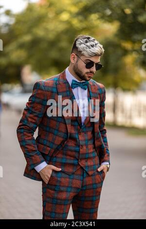 Bel giovane uomo d'affari che controlla il tempo sul suo orologio da polso Foto Stock