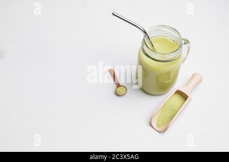 Latte Matcha con latte di cocco in vetro vaso su sfondo bianco Foto Stock