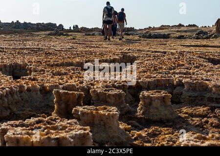 Dallol, Etiopia - Nov 2018: Turisti a piedi surreale deserto paesaggio Dallol, Danakil, Etiopia Foto Stock