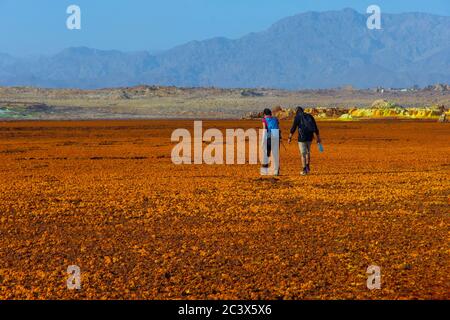 Dallol, Etiopia - Nov 2018: Turisti a piedi surreale deserto paesaggio Dallol, Danakil, Etiopia Foto Stock