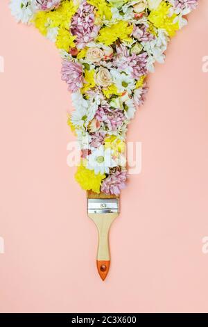 Pennello setole con vari fiori su rosa Foto Stock