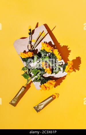 Flatlay creativo con forniture per artisti e girasoli in giallo Foto Stock