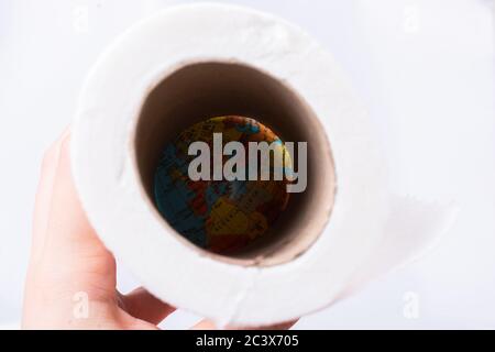 Una mano femminile prende un rotolo di carta igienica bianca in mano. Foto Stock