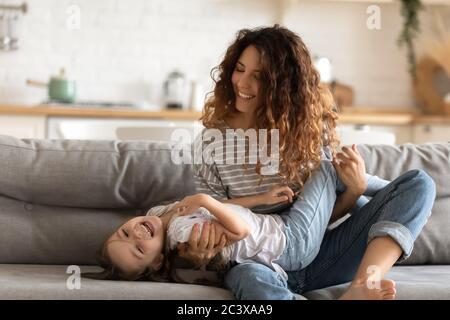 Felice giovane attraente madre che tiene sulle mani cute sorridente figlia. Foto Stock