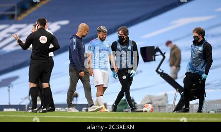 Sergio Aguero di Manchester City parla con il manager Pep Guardiola mentre esce dal campo ferito durante la partita della Premier League all'Etihad Stadium di Manchester. Foto Stock