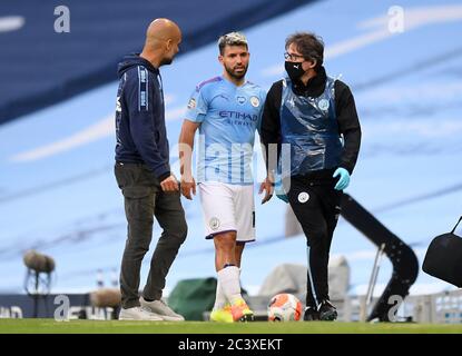 Sergio Aguero di Manchester City parla con il manager Pep Guardiola mentre esce dal campo ferito durante la partita della Premier League all'Etihad Stadium di Manchester. Foto Stock