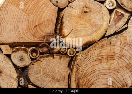 Screensaver, sfondi, texture, concetto di lavorazione del legno - uno sfondo in legno fatto di tronchi di alberi tagliati di diametri diversi sotto forma di A. Foto Stock