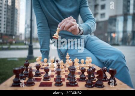 immagine esterna dell'uomo che tiene la pedina degli scacchi a bordo Foto Stock