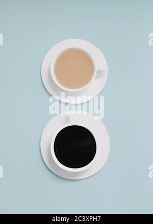Doppio caffè nella vista dall'alto immagine ravvicinata di due tazze di caffè nero e di caffè con latte su uno sfondo azzurro Foto Stock