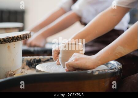 Pezzo da taglio femmina in ceramica con utensile a fresare primo piano. Donna uso taglierina di creta ad un pezzo grezzo di creta Foto Stock