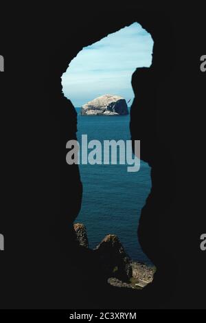 Faro su una scogliera. Vista attraverso l'apertura di un vecchio castello in rovina. Bass Rock, Scozia, Regno Unito Foto Stock