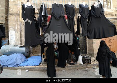 SANAA, YEMEN - 6 MARZO: Un uomo non identificato vende abiti tradizionali-abaye per le donne il 6 marzo 2010 a Sanaa, Yemen. I mercati aperti svolgono un ruolo centrale Foto Stock