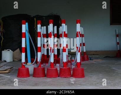 File di morsetti per ruote realizzati a mano in tubi in PVC e base in cemento attaccati a catene con lucchetti, verniciati a spruzzo senza segnale di parcheggio Foto Stock