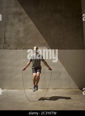 L'uomo esercita con salto con la corda Foto Stock