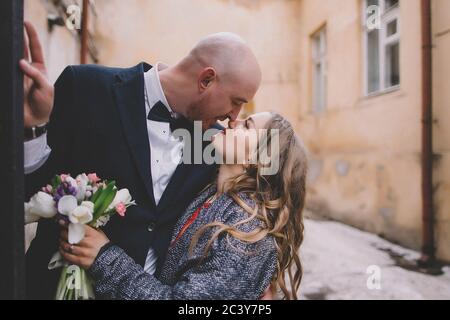 Una coppia appena sposata che si baciava sulla strada Foto Stock