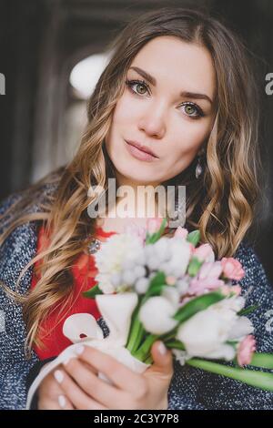 Ritratto di sposa che tiene bouquet di fiori Foto Stock