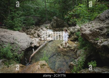 Ucraina, Crimea, giovane donna in piedi sulla roccia nel fiume Foto Stock