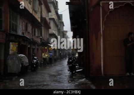 Una vista di un vicolo dello shopping da un incrocio in un giorno piovoso a Jaipur, Rajasthan, India. Foto Stock