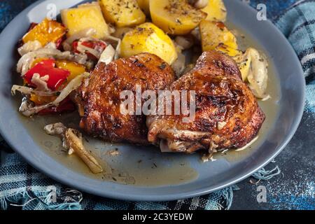 Cosce di pollo arrosto con patate su un piatto Foto Stock