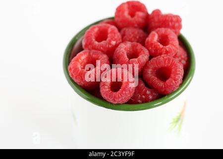 Biirasptilli ecologici freschi in tazza bianca da vicino isolato su sfondo bianco. Foto Stock
