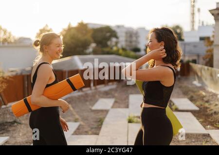 Due giovani donne belle in sportswear andando a fare allenamento sportivo, ginnastica, yoga. Un sano stile di vita sport concetto. Donne amicizia Foto Stock