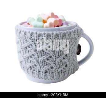 Bevanda calda e marshmallow multicolore in tazza, avvolta in un portabicchieri a maglia isolato su fondo bianco Foto Stock