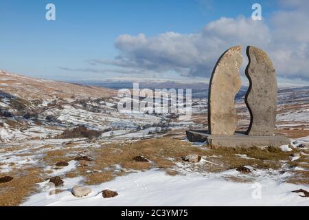 Una vista invernale innevata del 'Water Cut', una scultura in pietra di Mary Bourne, alta sul lato della valle di Mallerstang nel Parco Nazionale delle Valli dello Yorkshire Foto Stock