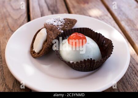 Cannolo e cassata siciliani. Piccola porzione su una piastra bianca. Dolci italiani Foto Stock