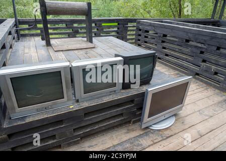 C'erano molte vecchie TV su un tavolo di legno. I vecchi televisori sono come spazzatura. Foto Stock