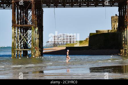 Brighton UK 23 giugno 2020 - un nuotatore di prima mattina emerge dal mare dopo un tuffo a Brighton oggi. Il tempo è previsto per ottenere ancora più caldo nei prossimi giorni con temperature previste per raggiungere oltre 30 gradi in parti del Sud-Est: Credit Simon Dack / Alamy Live News Foto Stock