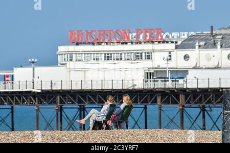 Brighton UK 23 giugno 2020 - i bagnanti del mattino presto godono del sole caldo bello sulla spiaggia e sul lungomare di Brighton. Il tempo è previsto per ottenere ancora più caldo nei prossimi giorni con temperature previste per raggiungere oltre 30 gradi in parti del Sud-Est: Credit Simon Dack / Alamy Live News Foto Stock