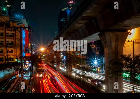 Bella immagine notturna del traffico su Sukhumvit Road con lunghi sentieri colorati di luci mobili auto, Bangkok, Thailandia Foto Stock