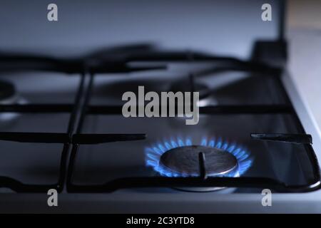 Il fuoco brucia su una vecchia stufa a gas di notte Foto Stock