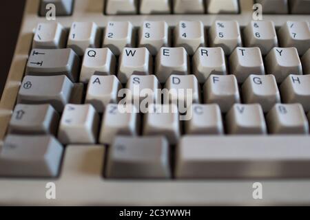 Tasto QWERTY sulla vecchia tastiera con tasti meccanici di colore avorio e grigio. Computer dagli anni '90 Foto Stock