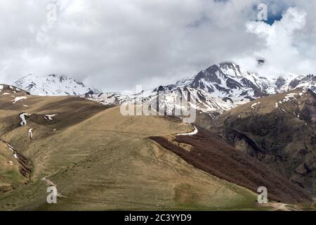 Montagne del Caucaso innevate, di fronte al 14 ° secolo, Tsminda Sameba aka Gergeti Trinity Church Georgia Foto Stock