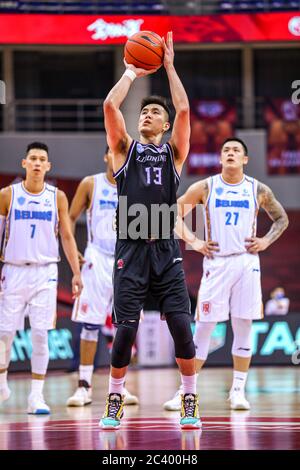 Il giocatore professionista di basket cinese Guo Ailun di Liaoning Flying Leopards, al centro, conduce il tiro libero durante una partita alla prima fase della ripresa della Chinese Basketball Association (CBA) contro Beijing Shougang Ducks, città di Qingdao, provincia di Shandong, nella Cina orientale, 20 giugno 2020. Pechino Shougang Ducks sconfisse Liaoning Flying Leopards con 91-82. La lega di basket cinese è ripartita dopo un periodo di quasi cinque mesi di chiusura, con meno giocatori stranieri e nessun tifoso in tribuna. Il CBA è stato sospeso il 24 gennaio, una settimana prima che fosse previsto il ritorno dopo una pausa primaverile alla fine di t. Foto Stock