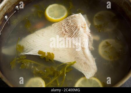 Un'ala di un raggio di spina, Raja clavata, che è stata impolata in acqua con limoni a fette e prezzemolo. Le ali di raggio sono spesso indicate come vittoria di skate Foto Stock