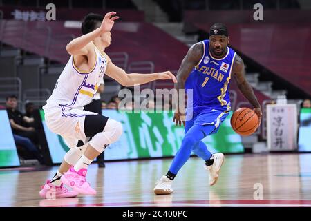 Il giocatore professionista americano di basket Tywon Ronell Lawson di Fujian SBS Xunxing Sturgeons, a destra, tiene la palla durante una partita alla prima fase della ripresa della Chinese Basketball Association (CBA) contro i Beijing Royal Fighters, città di Dongguan, provincia del Guangdong della Cina meridionale, 21 giugno 2020. I combattenti reali di Pechino sono stati sconfitti da Fujian SBS Xunxing Sturgeons con 108-121. La lega di basket cinese è ripartita dopo un periodo di quasi cinque mesi di chiusura, con meno giocatori stranieri e nessun tifoso in tribuna. Il CBA è stato sospeso il 24 gennaio, una settimana prima che fosse previsto il ritorno a seguito di un spr Foto Stock