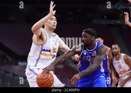 Il giocatore professionista americano di basket Tywon Ronell Lawson di Fujian SBS Xunxing Sturgeons, a destra, passa la palla durante una partita alla prima fase della ripresa della Chinese Basketball Association (CBA) contro i Beijing Royal Fighters, città di Dongguan, provincia del Guangdong della Cina meridionale, 21 giugno 2020. I combattenti reali di Pechino sono stati sconfitti da Fujian SBS Xunxing Sturgeons con 108-121. La lega di basket cinese è ripartita dopo un periodo di quasi cinque mesi di chiusura, con meno giocatori stranieri e nessun tifoso in tribuna. Il CBA è stato sospeso il 24 gennaio, una settimana prima che fosse previsto il ritorno dopo una sp Foto Stock